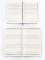An open lined notebook with cream pages and a purple ribbon bookmark, shown from above on a white background, with a second identical notebook below it.