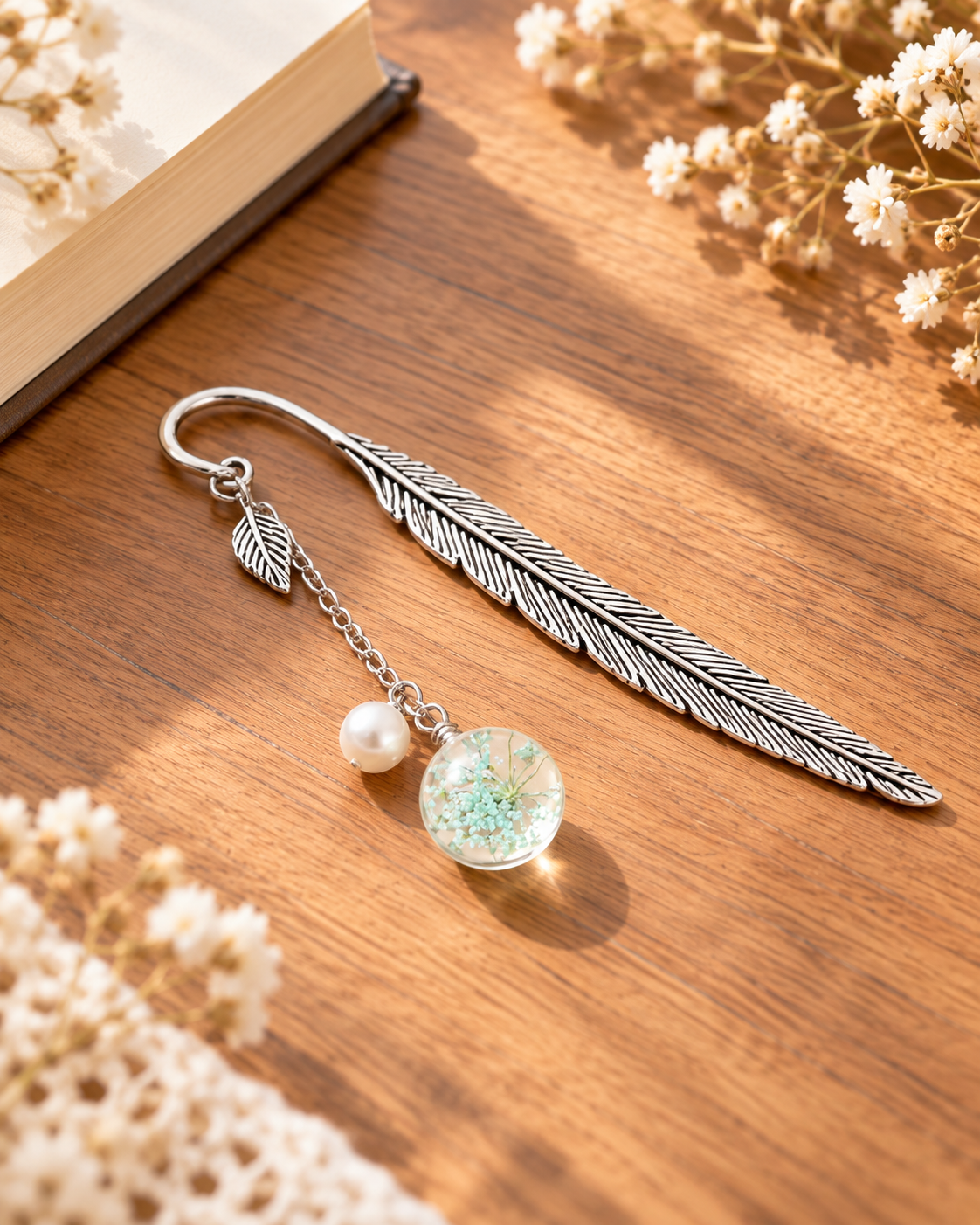 Silver-tone metal feather bookmark with a colorful floral charm for books and journals. Product photo 2 of 6.