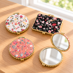 Boutique floral compact mirror with a padded exterior, gold-tone trim, and double mirrors. Product photo 1 of 4.