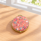 Boutique floral compact mirror with a padded exterior, gold-tone trim, and double mirrors. Product photo 2 of 4.