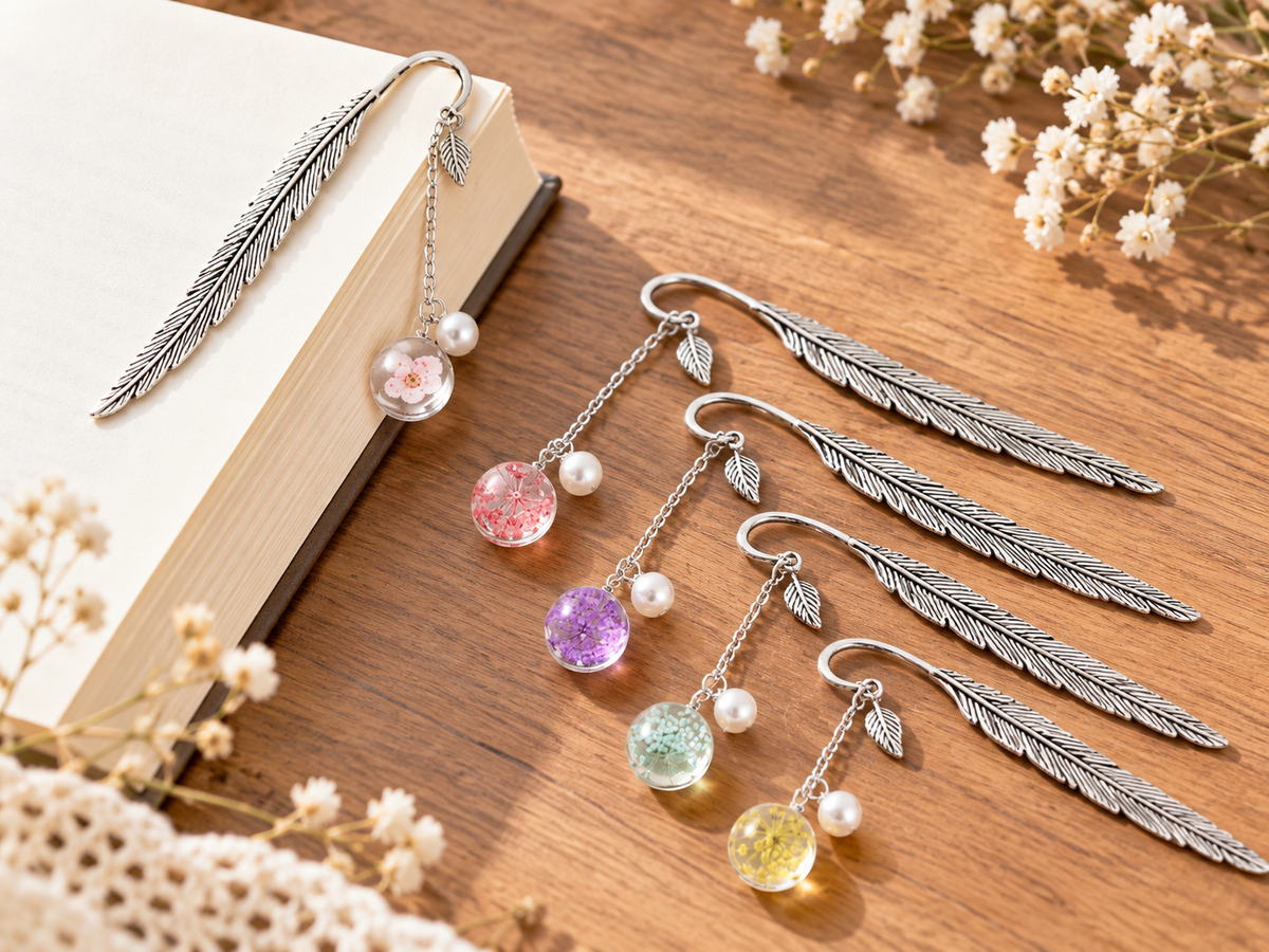 Silver-tone metal feather bookmark with a colorful floral charm for books and journals. Product photo 1 of 6.