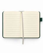 Open Into the Wild A7 pocket journal showing cream lined pages, a gray ribbon bookmark, and a dark green cover.