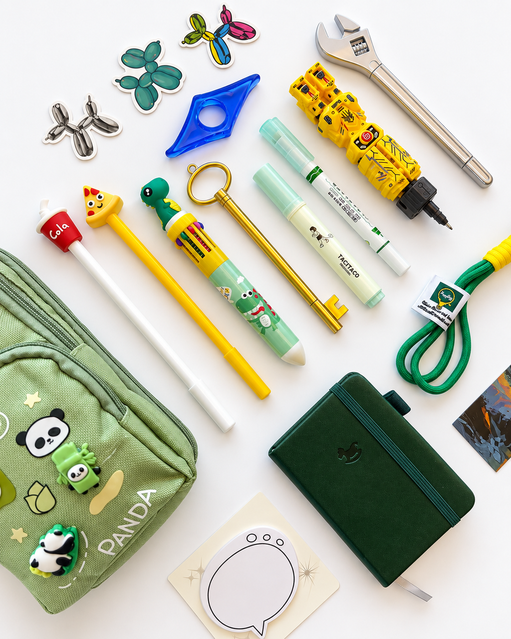 Close-up of the Into the Wild Premier Kids Collection showing the green panda pencil case, dark green A7 pocket journal, novelty pens, notepad, stickers, bookmark, page holder, and keychain.