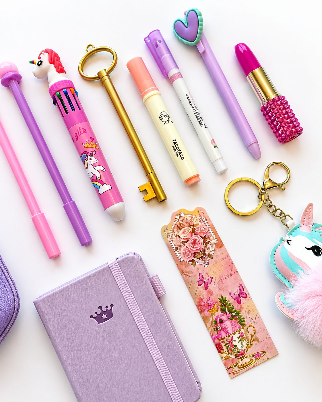 Close-up of the Once Upon a Time Premier Kids Collection showing the lavender A7 pocket journal, unicorn and key-shaped pens, highlighter, marker, bookmark, and fluffy unicorn keychain.