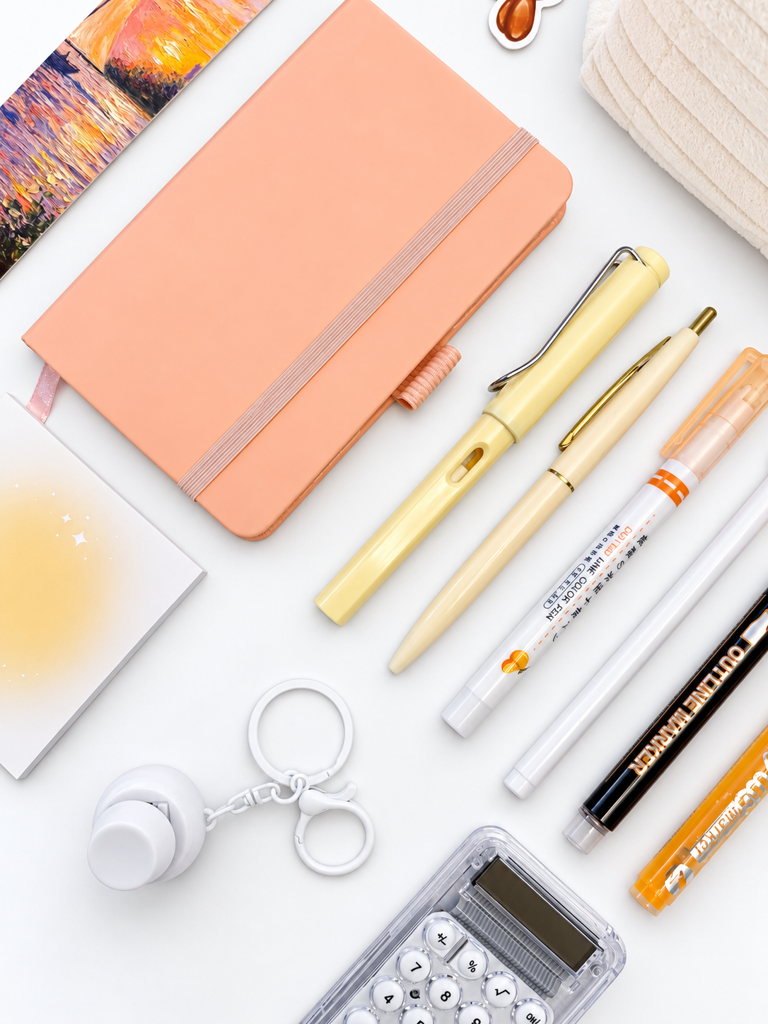 Close-up of the Orange Sherbert orange and peach kids stationery collection showing the A6 journal, coordinating writing tools, calculator, sticky notes, fidget keychain, bookmark, and pencil case.