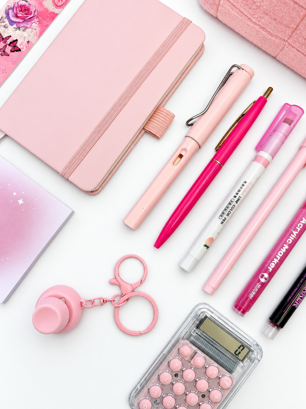 Close-up of the Strawberry Shortcake pink kids stationery collection showing the A6 journal, coordinating writing tools, calculator, sticky notes, fidget keychain, bookmark, and pencil case.