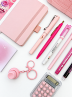 Close-up of the Strawberry Shortcake pink kids stationery collection showing the A6 journal, coordinating writing tools, calculator, sticky notes, fidget keychain, bookmark, and pencil case.