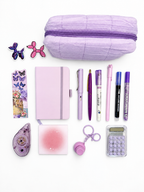 Sugar Plum purple kids stationery collection flat lay with pencil case, A6 journal, writing tools, calculator, sticky notes, tape roller, fidget keychain, bookmark, and stickers.
